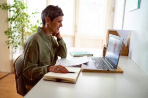 Woman using video call on her laptop at home with financial professional.