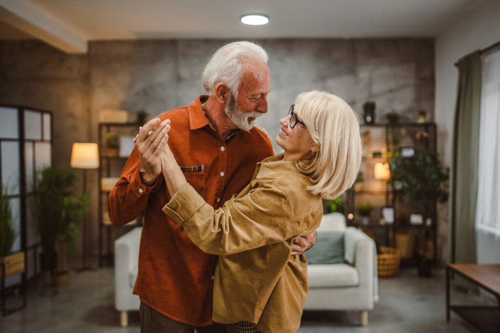 senior couple husband and wife love dance and hug at home have fun
