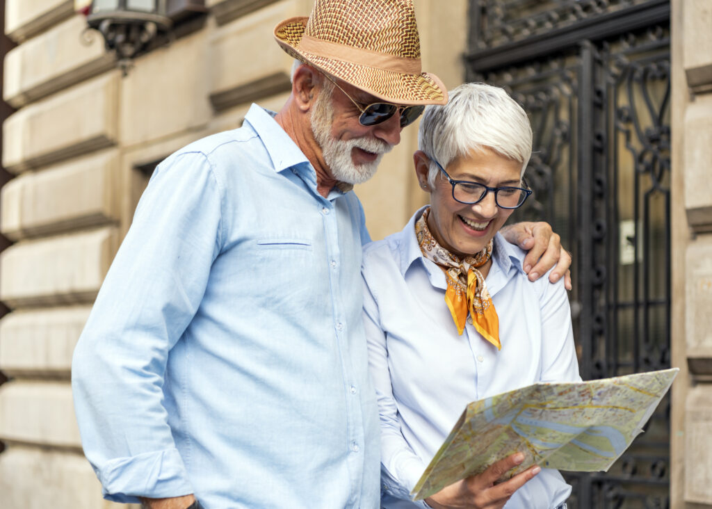 A mature Couple Walking in the City Streets and Looking at Tourist Map.