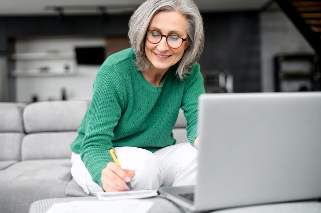 Confident mature woman using laptop computer while planning retirement