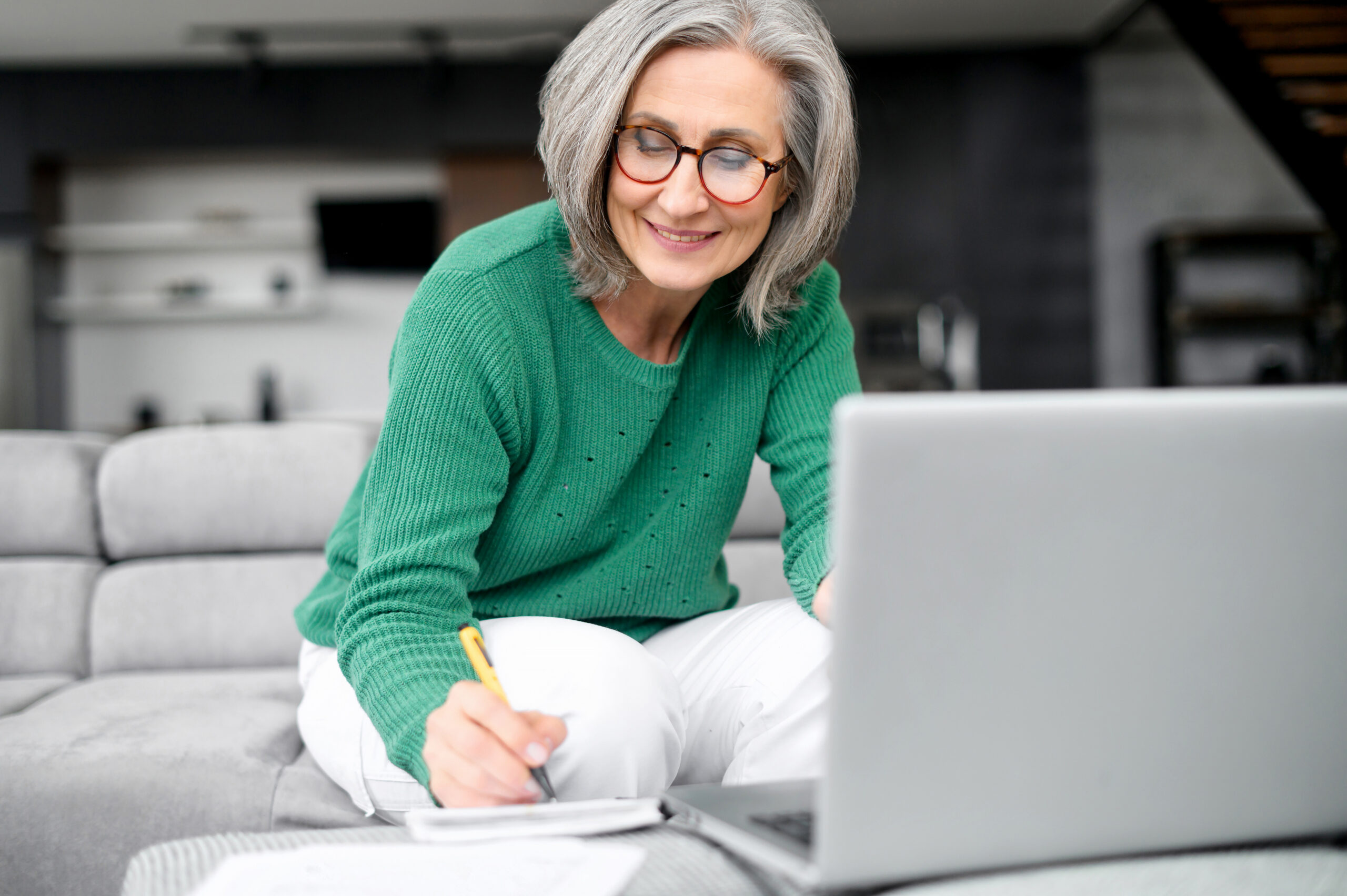 Confident mature woman using laptop computer while planning retirement